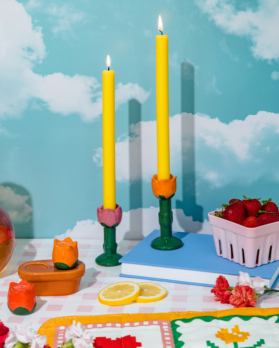 red and orange tulip salt and pepper shakers with brown pot tray on a table with candle holders, and strawberries