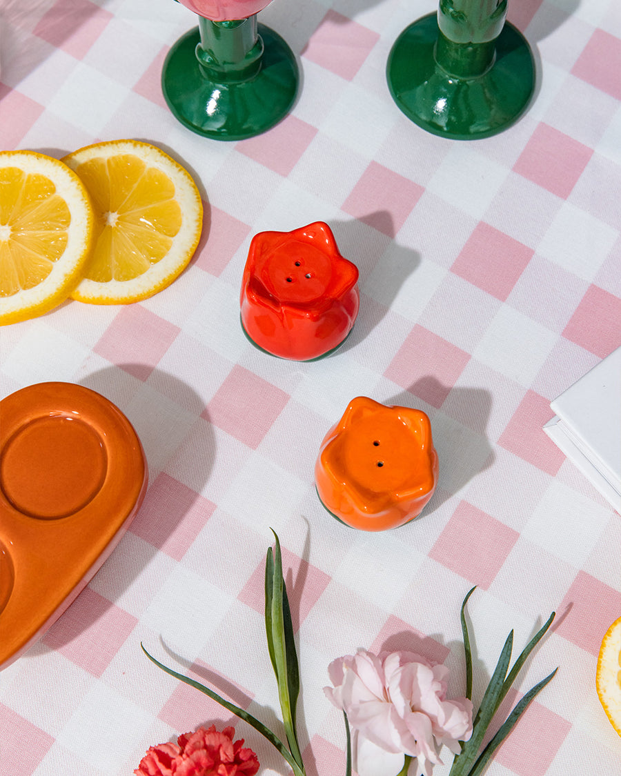 separated red and orange salt and pepper shakers