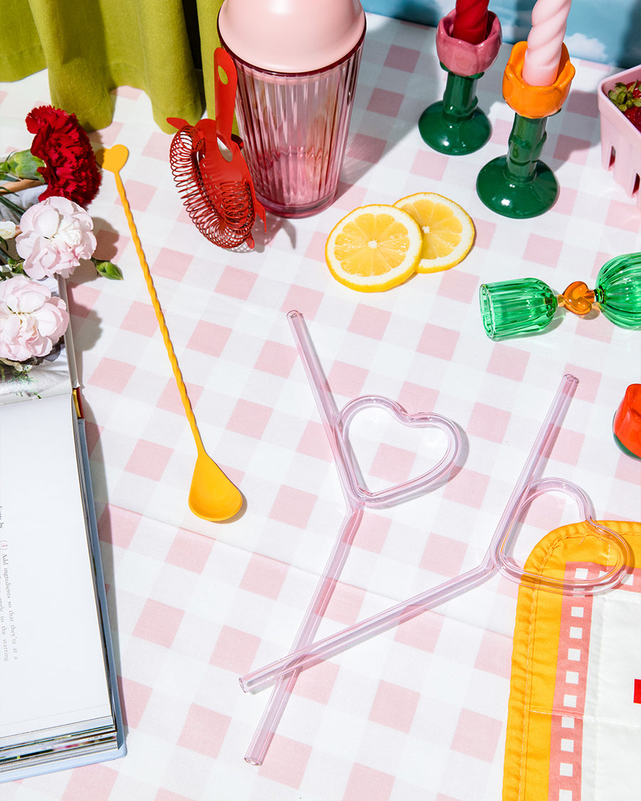 pink glass heart shaped straws on a pink checkered table