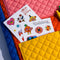 up close of pink, yellow, red, and blue quilted laptop tote with various pockets