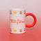 White mug with red handle, with cherry, start and tulip illustrations, that says "you're the cherry on top!" on a red gradient background