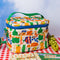 white quilted lunch bag with all over charcuterie print with green and blue trim on red and white checkered table cloth