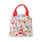 light pink lunch tote with all over cherry and flower print and red handles