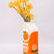 side view of Porcelain orange juice carton-shaped vase with flowers inside