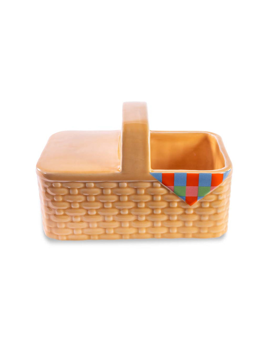 brown picnic basket flower planter with hint of plaid picnic blanket