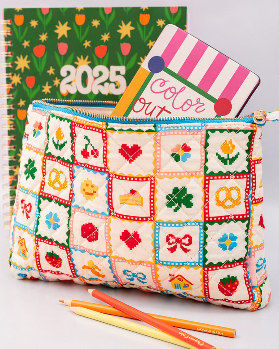 white quilted pouch with various hearts, fruits, smiley faces with various items inside