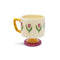 top view of cream 10 oz ceramic mug with yellow handle, pink pedestal base and pink tulip print