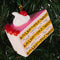 ceramic cake slice shaped ornament with sprinkle center and cherry and whipped topping on top on a tree