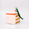 back view of ceramic cake slice shaped ornament with sprinkle center and cherry and whipped topping on top