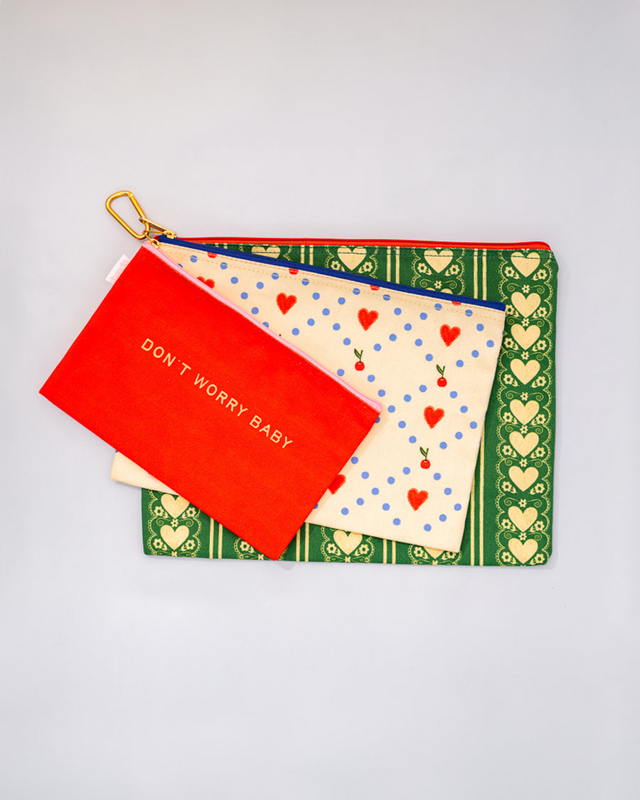 set of three typography and printed travel pouches with gold carabiner