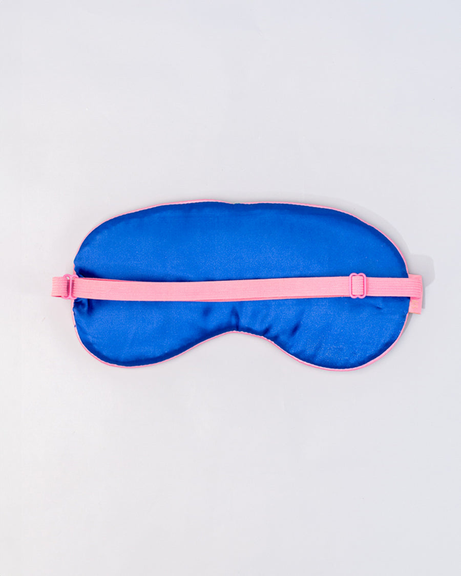 dark blue silk back of dark green sleep mask with pink and white embroidered 'greeting from paradise' with pink adjustable strap