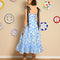 back view of model wearing white/light blue midi dress with ruffle hem, black tie straps and all over blue flower print