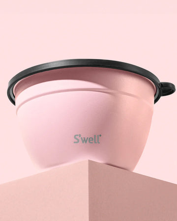 light pink salad bowl set and smaller container for dressing on a pink background