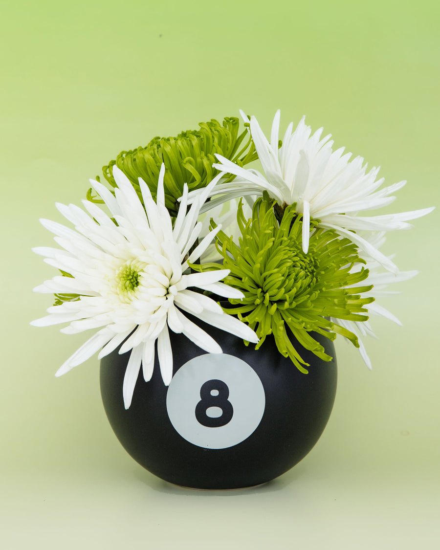 8 ball shaped vase with white and green flowers