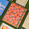pink 17-month large planner with colorful tulip print and yellow star design on grass and surrounded by other planners