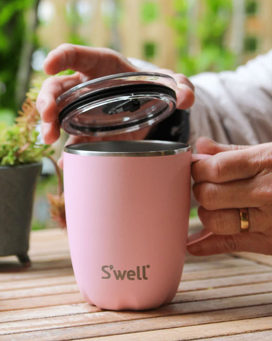 model using light pink stainless steel mug with lid