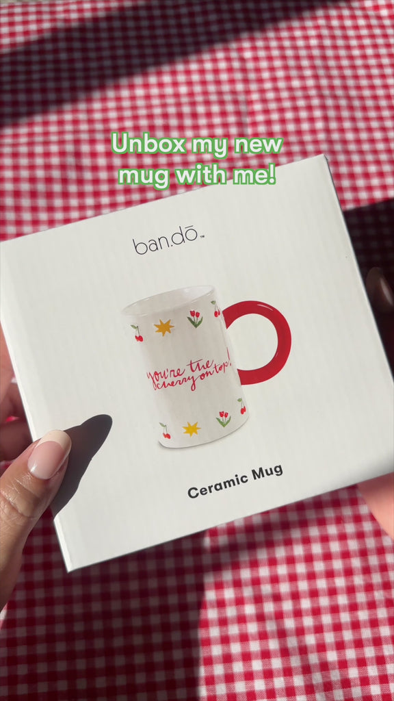 unboxing of white mug with red handle and 'you're the cherry on top' across the front