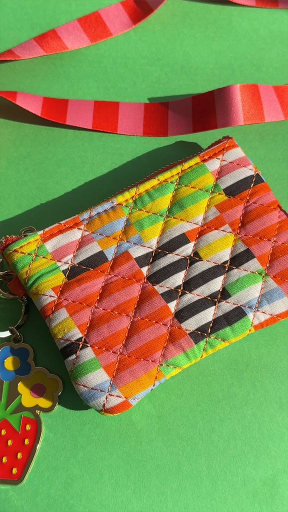 model showcasing various stripe pouch with colorful lanyard