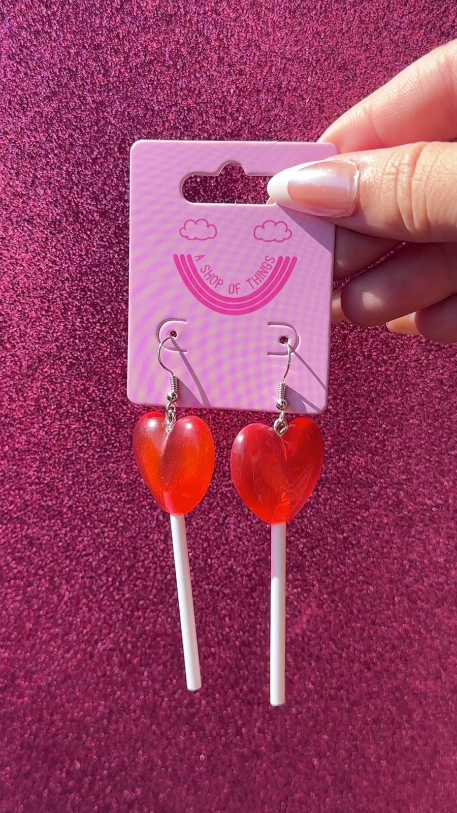 model showcasing red heart lollipop earrings