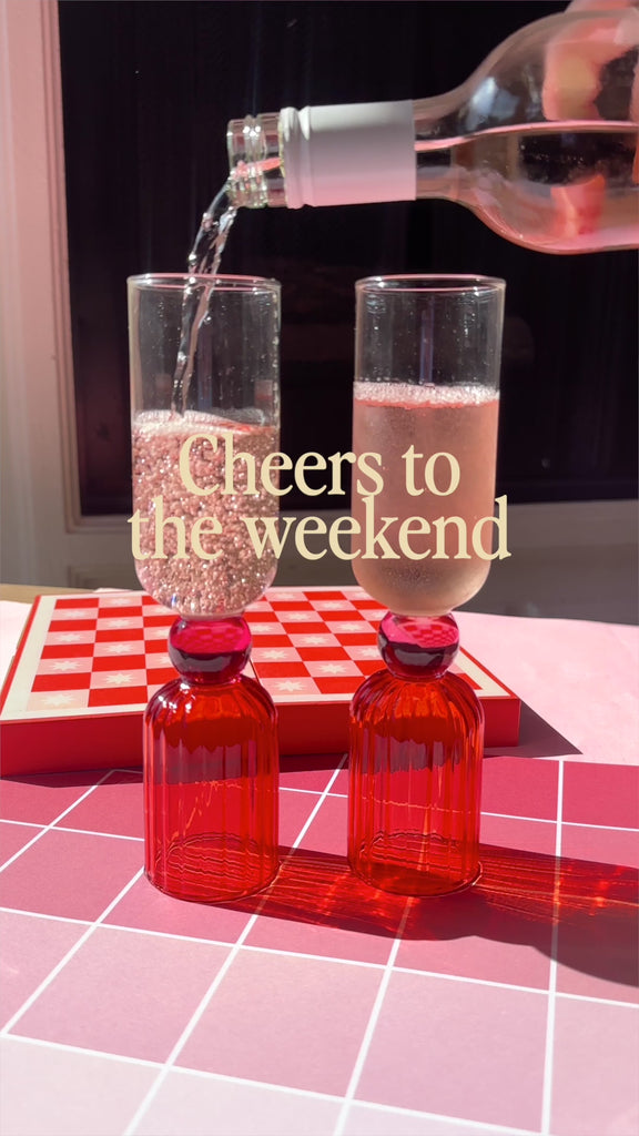 model pouring a beverage in pink bar glass set