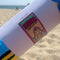 model unrolling giant 'emotional rollercoaster' beach towel on the beach