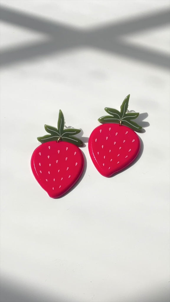 model showcasing strawberry shaped earrings