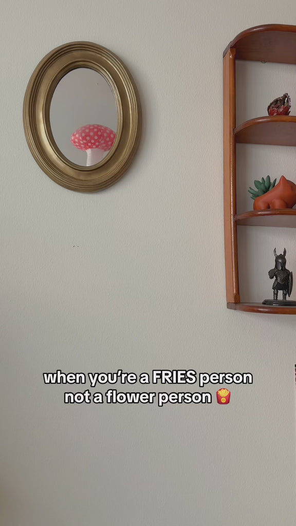 model putting stuffed fries in white and red checker wall vase