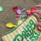 model using small yellow and white stripe 'doing my best' pouch at the beach