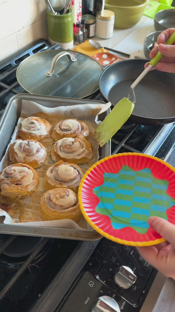 model putting cinnamon bun on colorful dessert plates