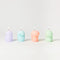 set of four goober mini candles in purple, blue, coral and green lit