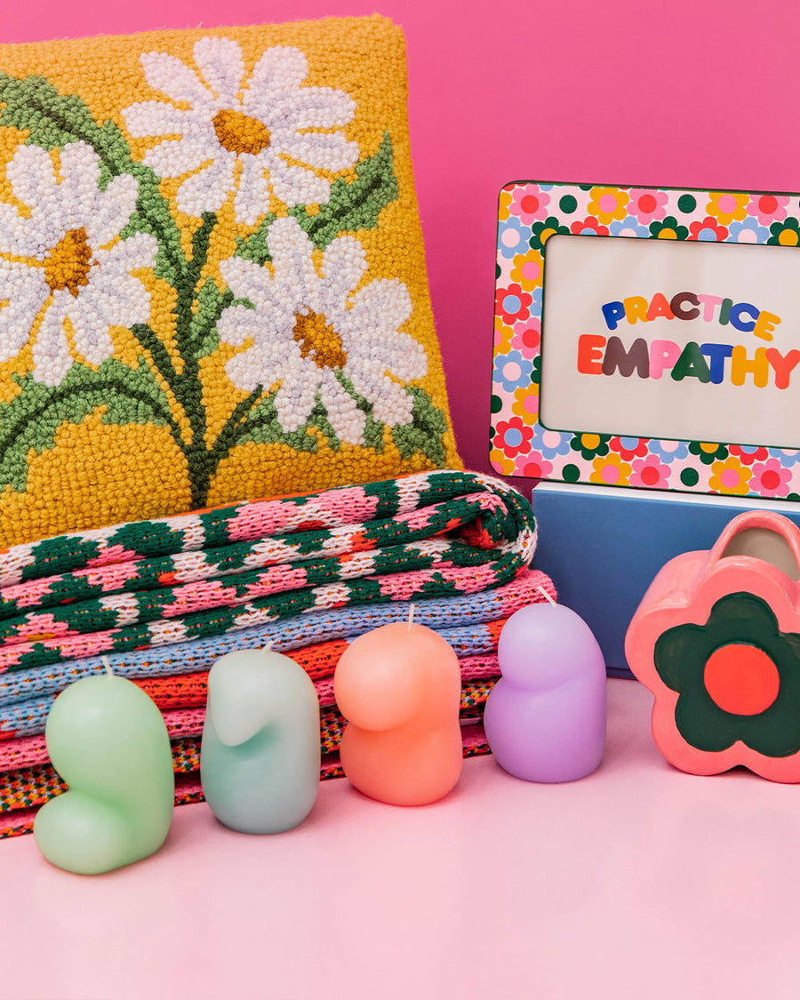 editorial image of set of four goober mini candles in purple, blue, coral and green