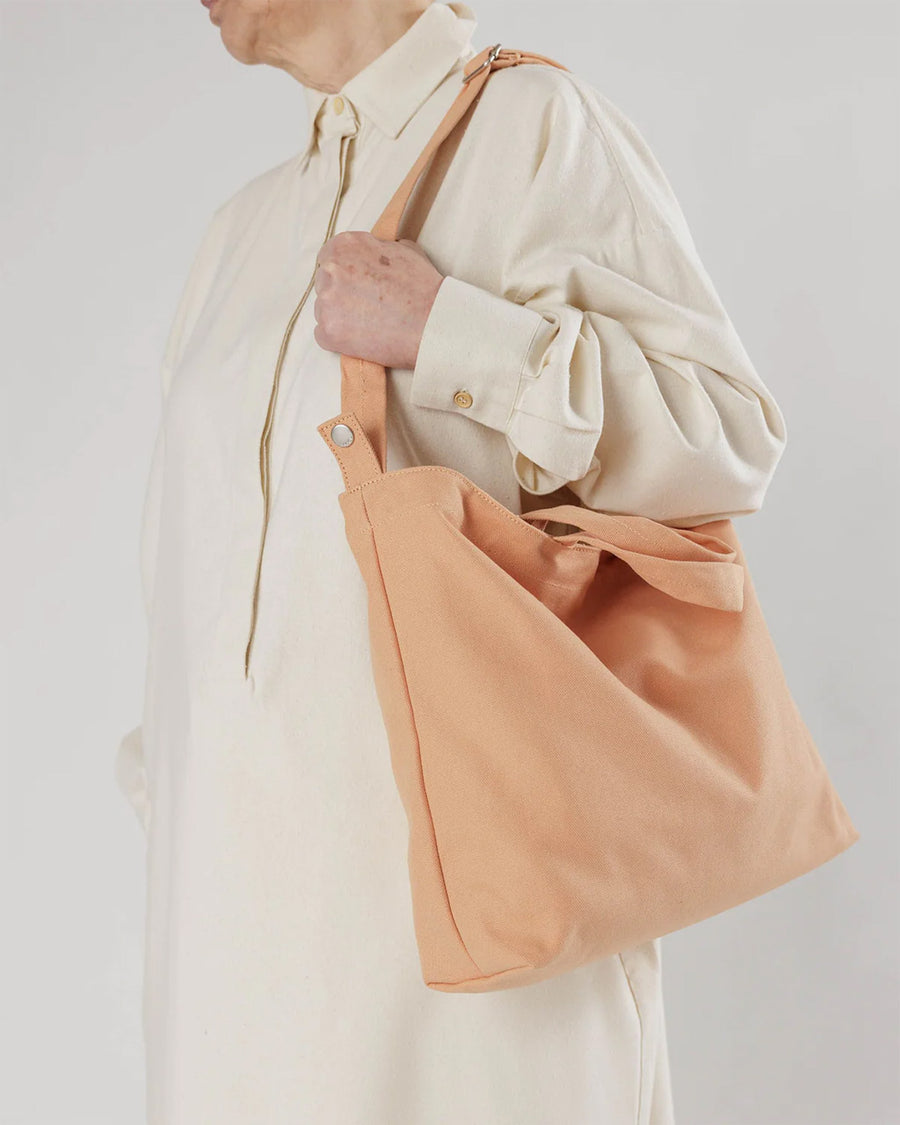 model carrying peachy pink horizontal duck bag 