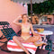 model wearing yellow swim suit with green and pink swirl floral print sitting on an outdoor lounge chair 