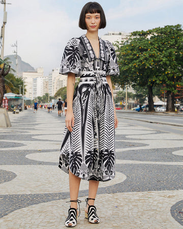 model wearing black and white abstract print midi dress with tie waist and elongated collar