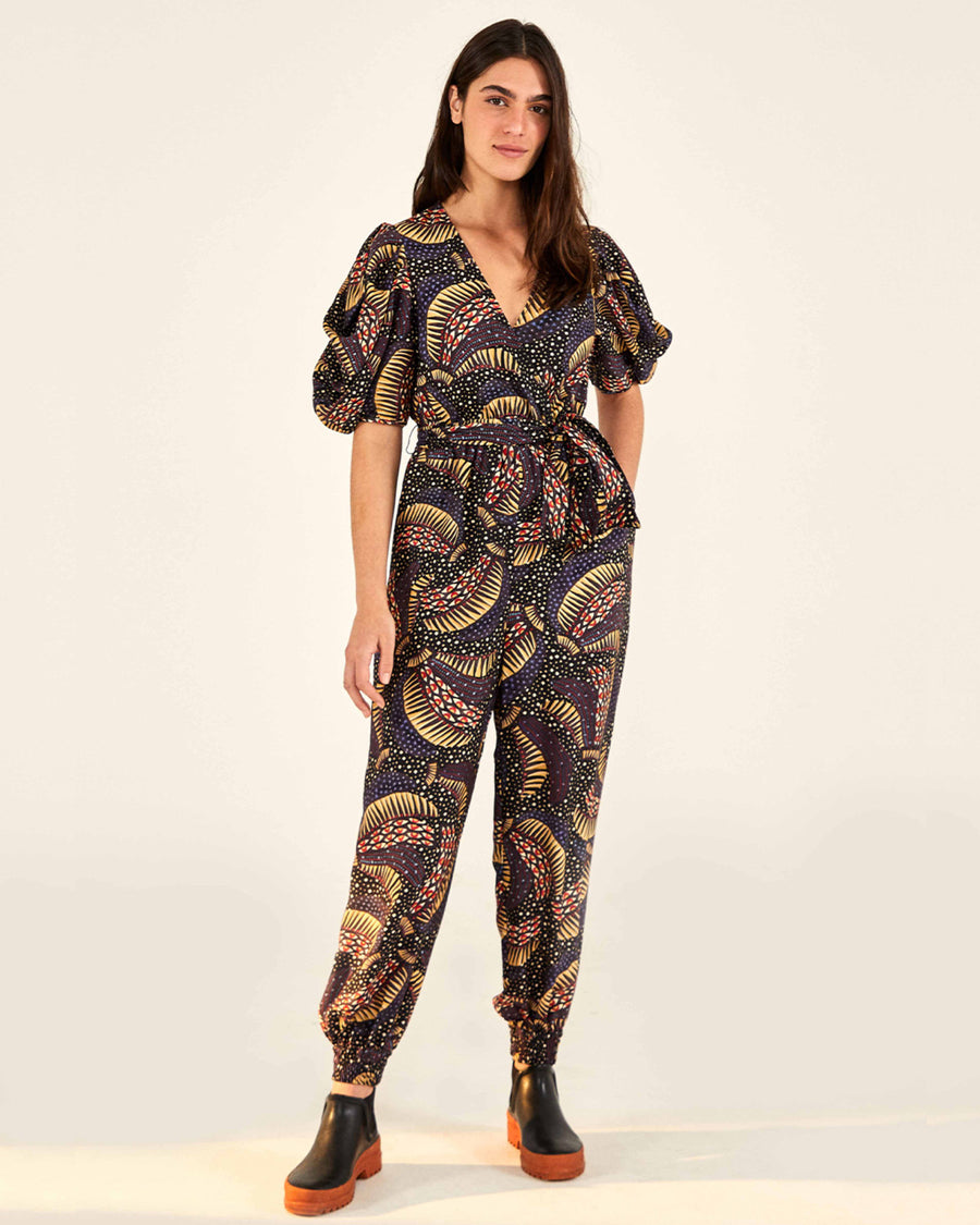 model wearing banana print jumpsuit with black and orange boots