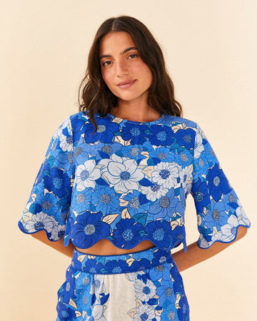 model wearing blue and white applique cropped top with flutter sleeves and matching skirt