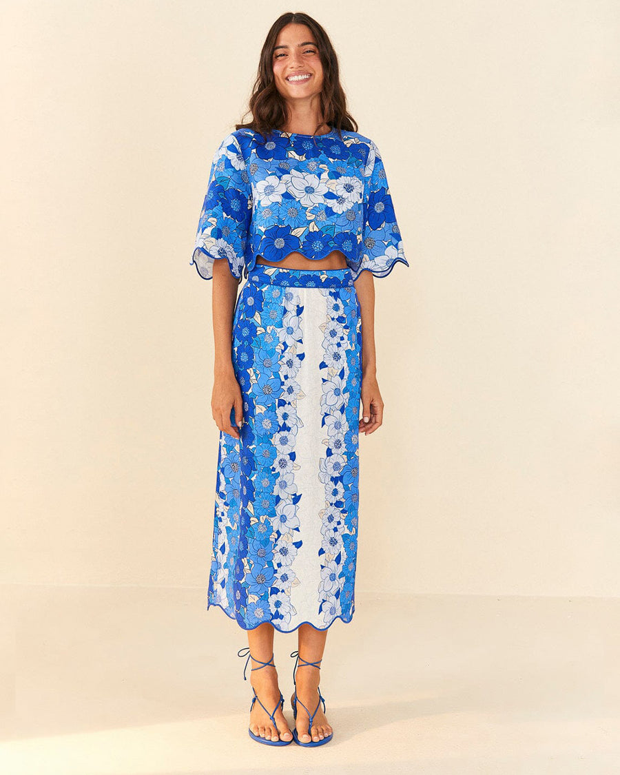 model wearing blue and white applique cropped top with flutter sleeves and matching skirt