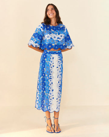 model wearing blue and white applique cropped top with flutter sleeves and matching skirt