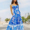 model wearing blue and white abstract floral tiered midi dress with unique strap detail