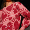 up close of model wearing pink cropped sweater with all over sequins and graphic heart print