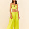 model wearing model wearing lime green linen pants with wide legs and matching top