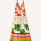 still image of  white maxi dress with various different multicolor prints, fruit charms on straps and deep v neckline