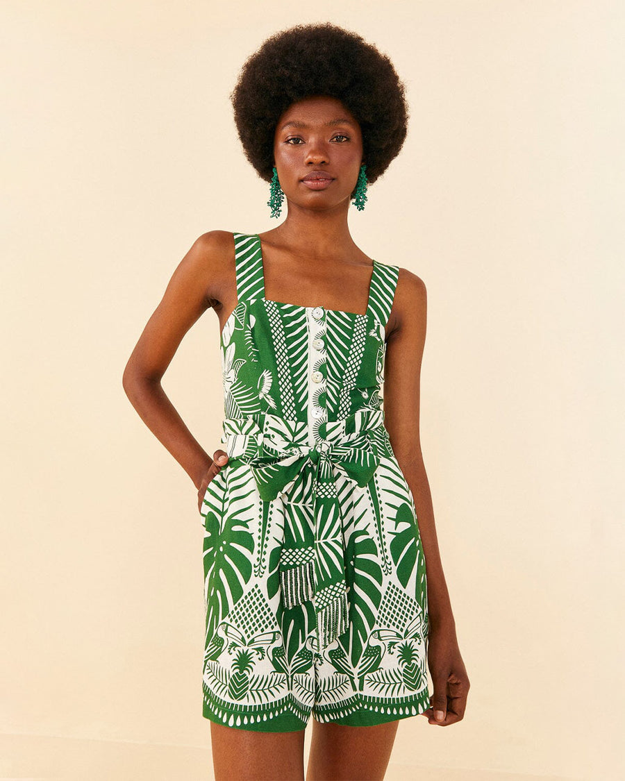 model wearing green and white tropical print tank romper with button front