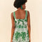 backview of model wearing green and white tropical print tank romper with smocked back