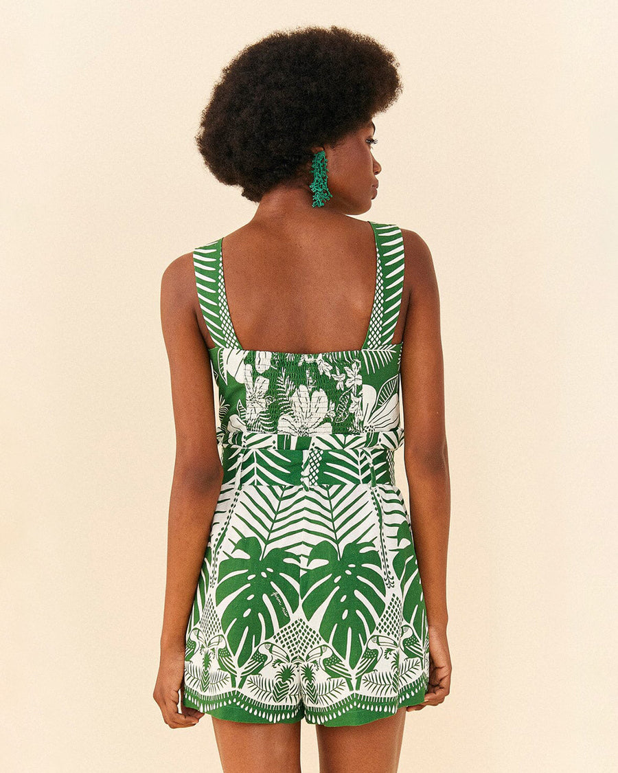 backview of model wearing green and white tropical print tank romper with smocked back