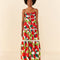 model wearing large tomato print midi dress with lace inset tiers and beaded neck ties