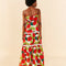 backview of model wearing large tomato print midi dress with lace inset tiers and beaded neck ties