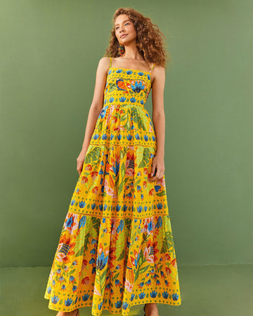 model wearing yellow swiss dot maxi dress with vibrant tropical floral print