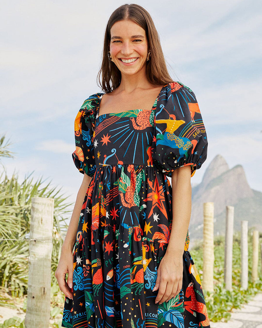 model wearing navy mini dress with vibrant zodiac sign graphics and short puff sleeves