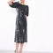 from view of model wearing black sequin midi dress with sequins, open back and puff sleeves